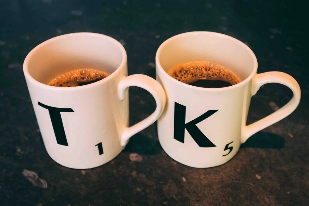 Scrabble K & T cups with black coffee in them. 