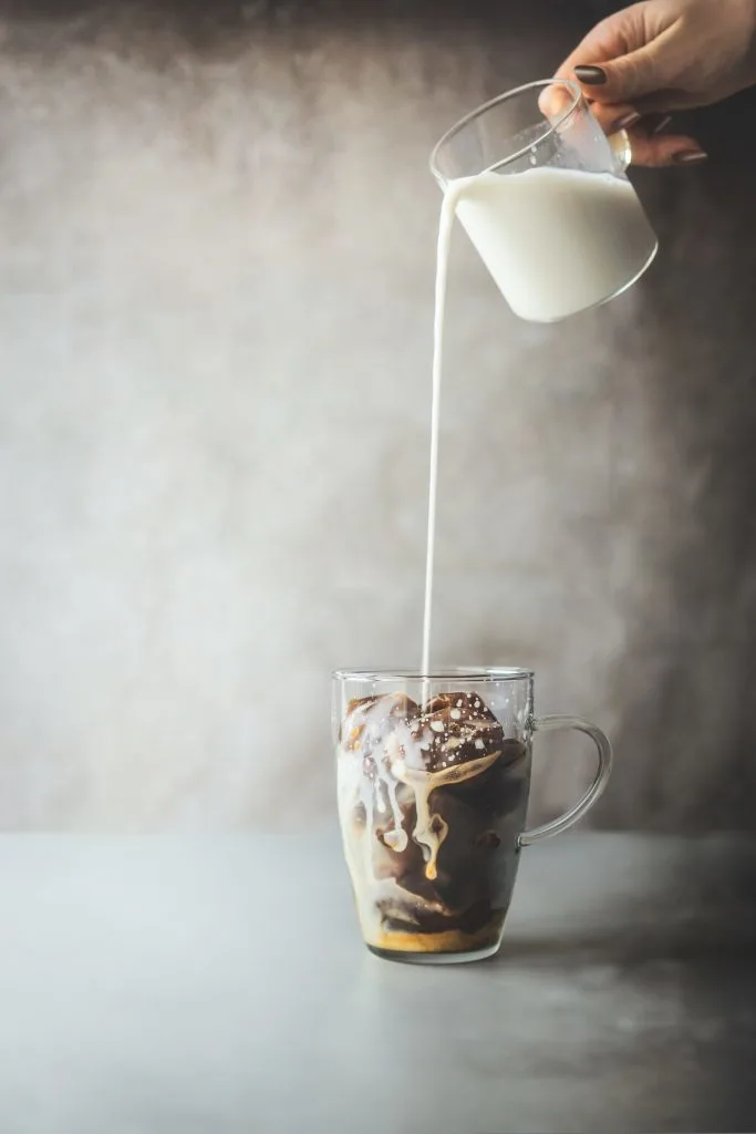Ice coffee cubes in a glass with milk