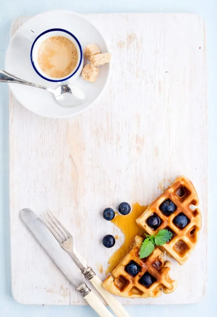Espresso coffee cup, soft belgian waffles with fresh blueberries and marple syrup