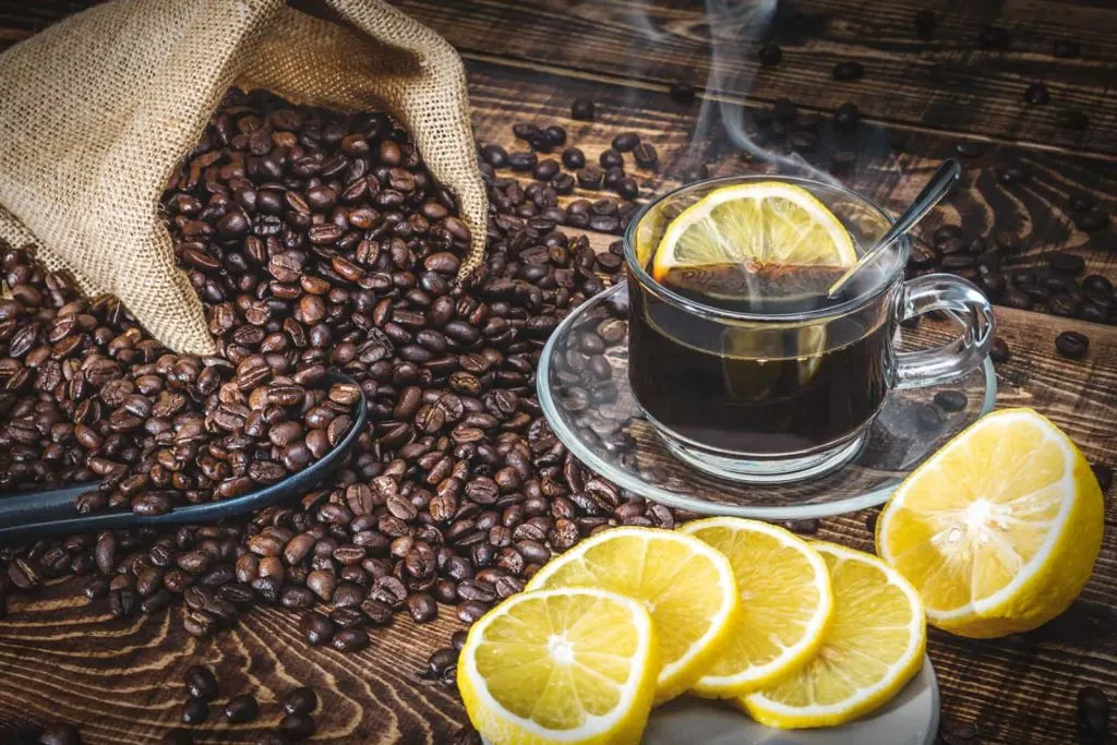 Espresso surrounded by lemon and coffee beans.